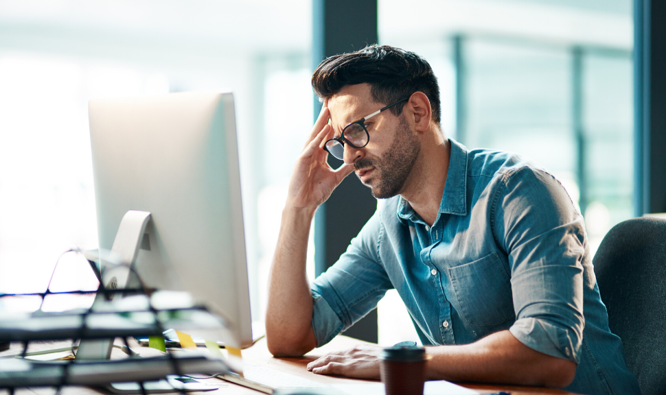 businessman looking displeased while using a computer